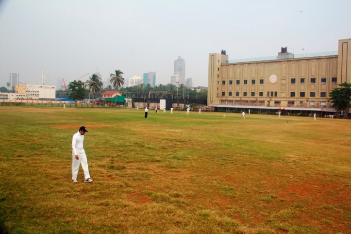 The deep backward square leg fieldsman ponders the state of the outfield. 